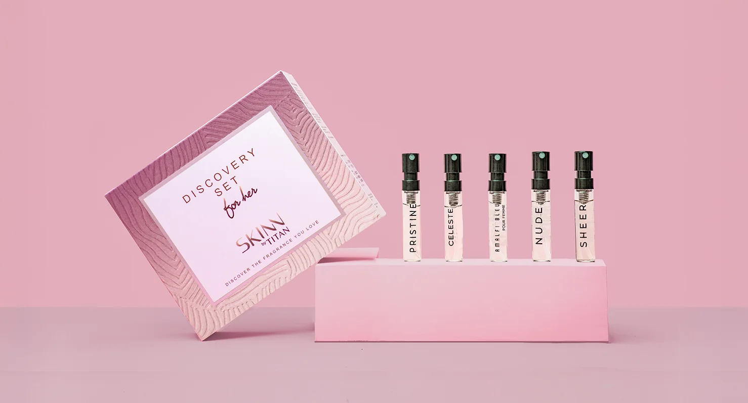 SKINN by TITAN perfume discovery sets for him and for her, shown open side-by-side to reveal the five sample fragrance vials in each presentation box.
