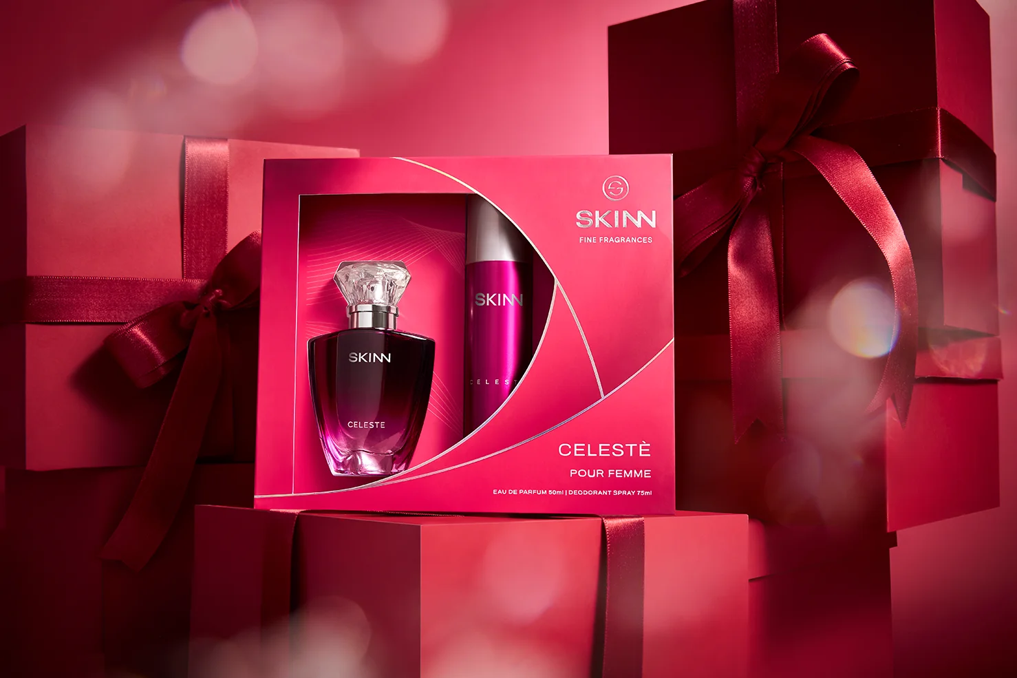 An elegant lifestyle photograph of the Titan Skinn Celeste women's perfume gift set, showcasing the final packaging designed by Kern Culture. The vibrant magenta coffret, containing the floral EDP and deodorant, is set against a festive backdrop with soft bokeh lights, embodying the joyful and mischievous spirit of the Celeste fragrance.